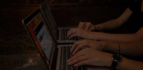 women typing at laptops